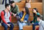 5 students sitting on the stairs and discussing